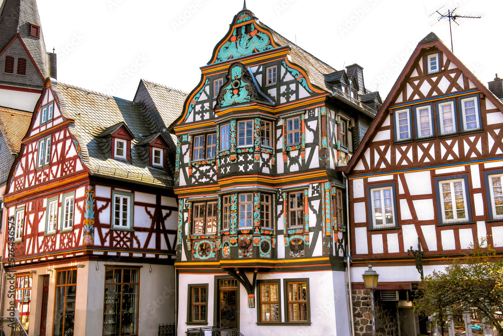 Die bunten Fassaden von drei in einer Reihe stehenden Fachwerkhäusern in der historischen Altstadt von Idstein im Taunus, Hessen