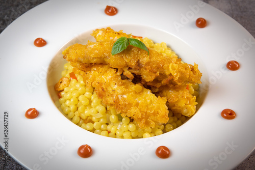 Recipe for chicken tenders with corn flakes and Italian Piombo pasta risotto and peppers. High quality photo
