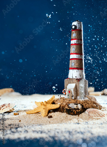 wooden lighthouse made of driftwood. marine composition with sand, shells and wave splashes