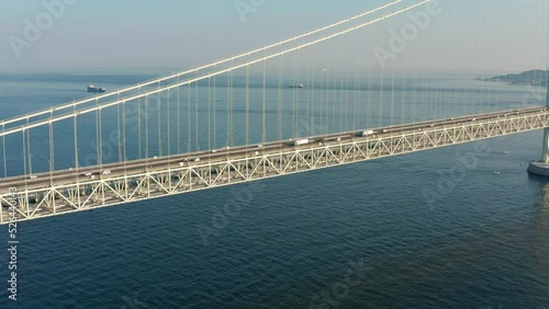 Vehicles Cross Akashi Kaikyo Bridge to Awaji Island, Aerial View on Warm Sunny Day photo