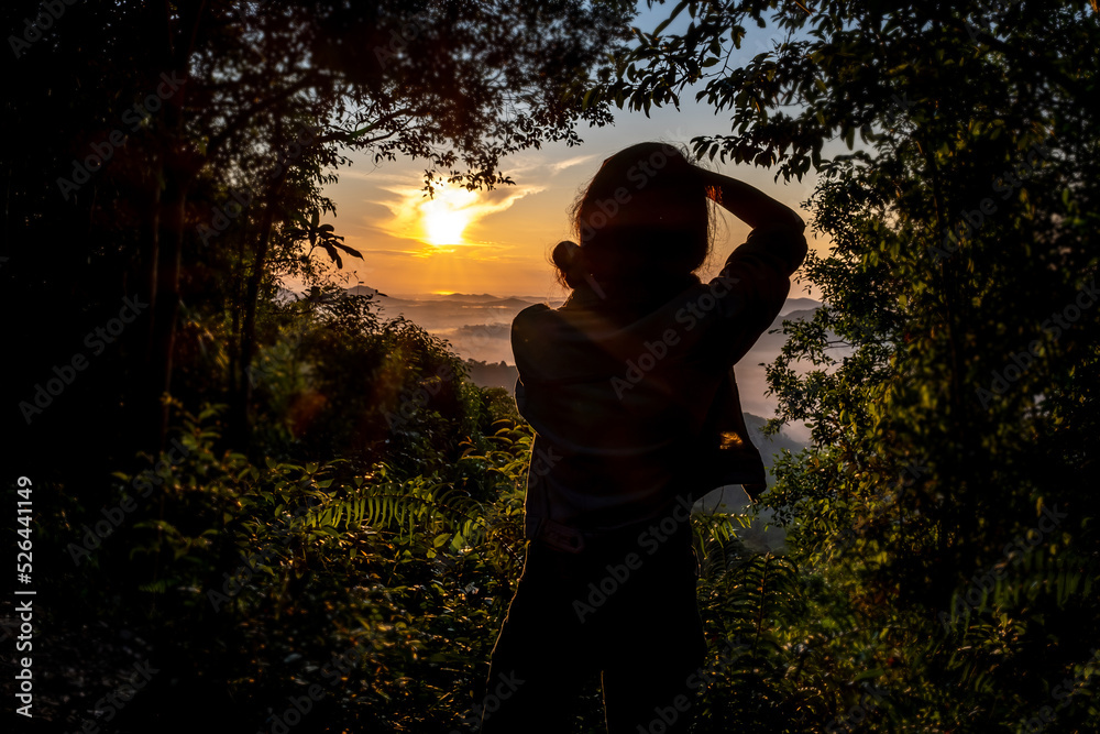 Silhouette of woman with camera. Woman taking photo scenic mountain view among sunrise on mountain in Hat Yai, Thailand. Silhouette of woman with camera. Woman taking photo scenic mountain view among sunrise on mountain in Hat Yai, Thailand.