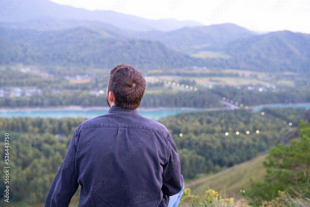 view from the top of the mountain. a man looks at nature from the mountain. mountain trip