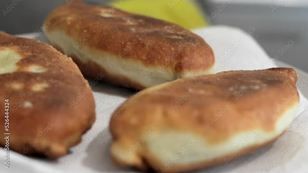 A woman in the home kitchen prepares fried pies with filling. Appetizing homemade pies close-up. Ready-made fried pies with different fillings with a golden crispy crust. A woman in the home kitchen prepares fried pies with filling. Appetizing homemade pies close-up. Ready-made fried pies with different fillings with a golden crispy crust.