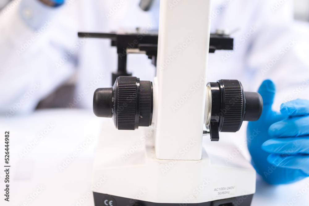 professional research scientist using microscope in science chemistry laboratory, medical technology for biology or microbiology medicine discovery, scientific equipment for experiment in hospital lab