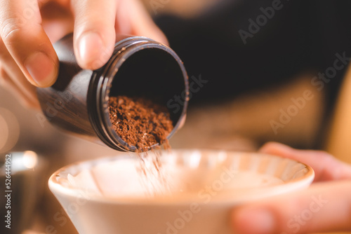barista holding hand grinde...