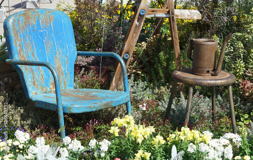 Wallpaper Mural Rusty old blue chair amidst greenery and flowers in a sunny garden Torontodigital.ca