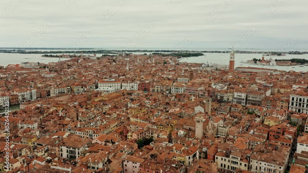 The drone flies over the orange rooftops of traditional Venetian houses. Narrow water channels instead of streets, aerial view, Italy The drone flies over the orange rooftops of traditional Venetian houses. Narrow water channels instead of streets, aerial view, Italy