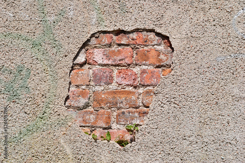 Damaged Cement Covered Wall with Exposed Brick photo