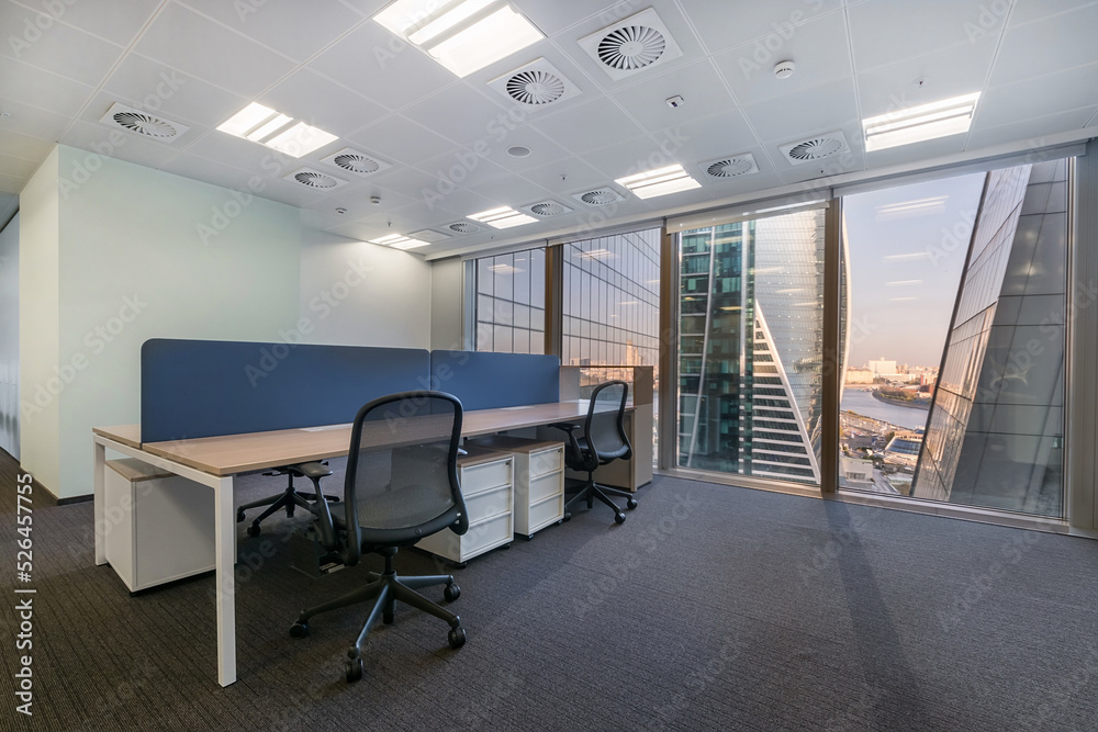 Fototapeta premium Office space with light walls, gray flooring. View from the panoramic window.