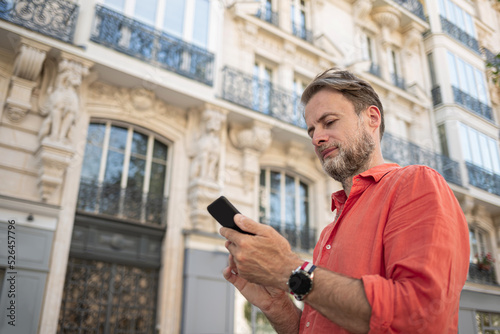 Canvas Print Caucasian man (businessman) using smartphone in the elegant street of Paris