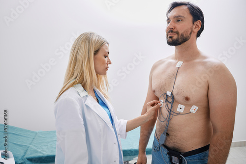 Cardiologist tracked adult man with heart condition using Holter monitoring with ECG sensors photo