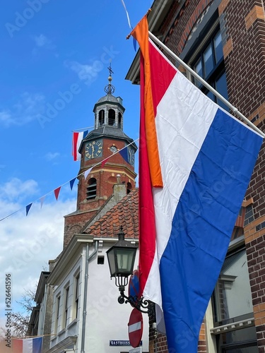 Vertical shot of the flag of the Netherlands with Sint-Lambertuskerk Church in the background. photo