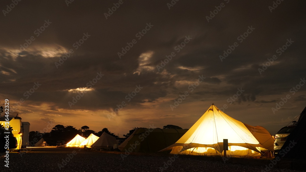 Leuchtende Zelte auf Campingplatzt mit Dramatischem Nachthimmel