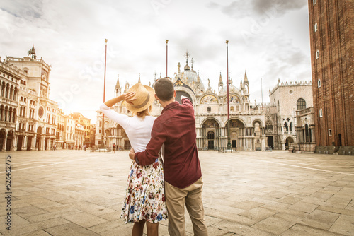 Happy beautiful couple of lovers doing romantic trip in Venice, Italy - Tourists visiting historic town of Venice and St. Mark square