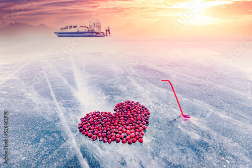 Cocktail kiss winter of lake Baikal with straw and hole in pure ice with cranberry heart photo