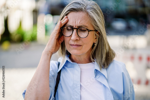 Принти на полотні Feeling hard headache, migraine mature grey haired woman 50s, 60s, standing outdoors holding her head