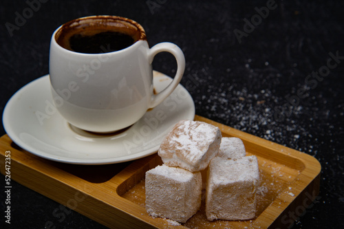 Turkish Delight and Turkish coffee in wooden plate on black background