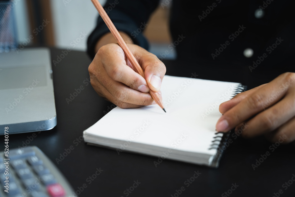Male hands taking notes on a handwritten notepad, creative writing. Male hands taking notes on a handwritten notepad, creative writing.