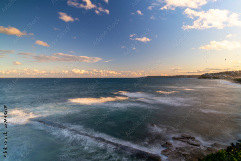 Long exposure shot of the blue waters at Bar Beach at sunset in Newcastle, New South Wales, Australia