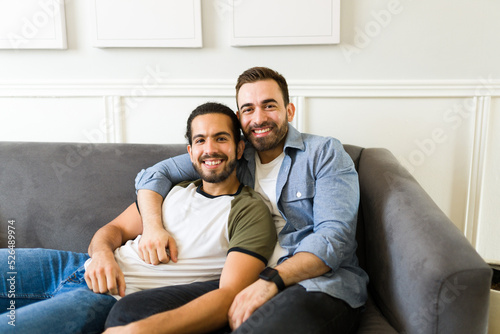 Attractive happy gay couple cuddling on the couch