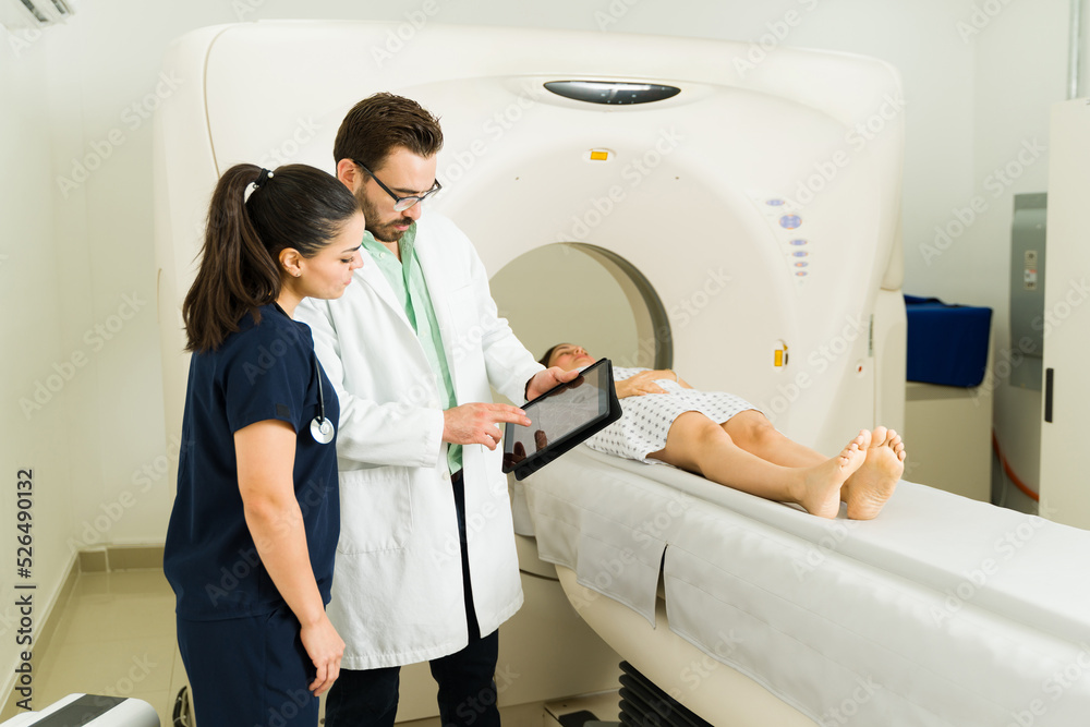 Doctor and nurse checking the test results after doing a cat scan Doctor and nurse checking the test results after doing a cat scan