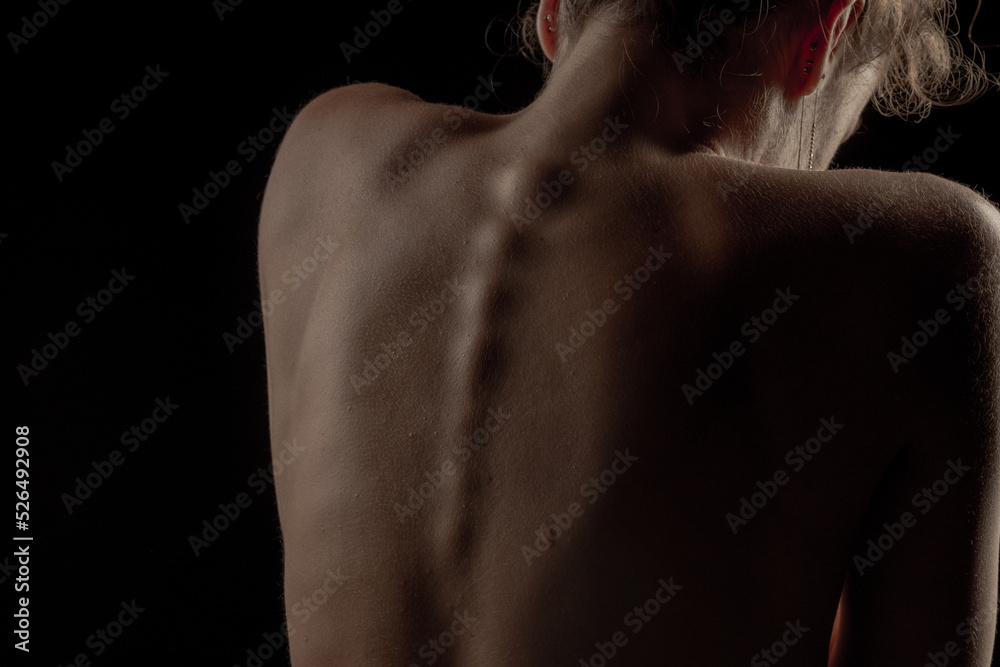 beautiful female back on dark background, spine health concept