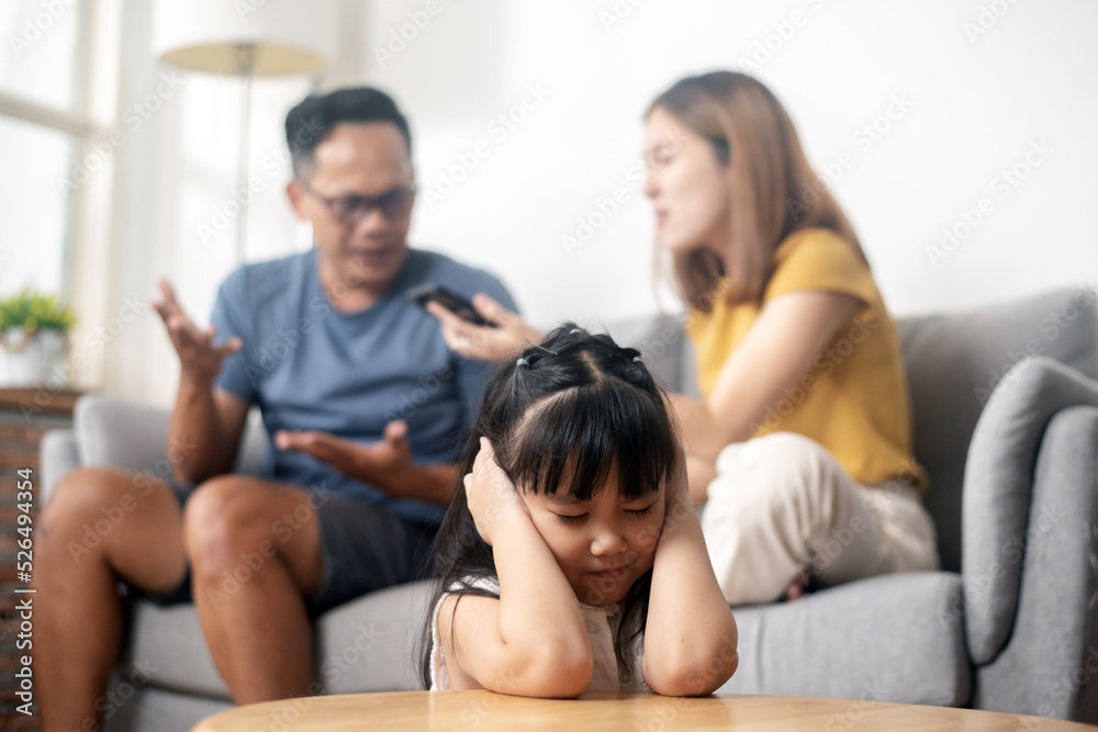 Domestic problem in family, parents quarreling, daughter covering her ears for not wanting to listen, mother scolding her daughter.