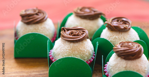 Brigadeiro Gourmet com leite em pó e creme de avelã em forminhas verdes sobre uma tábua de madeira. Comida brasileira, sobremesa. Doce tradicional em festas e eventos. photo