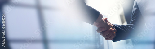 Businessmen making handshake with partner, greeting, dealing, merger and acquisition, business cooperation concept, panoramic banner, copy space for business, finance and investment background photo