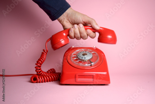 Make that call today - classic rotary dial telephone being picked up by a hand photo