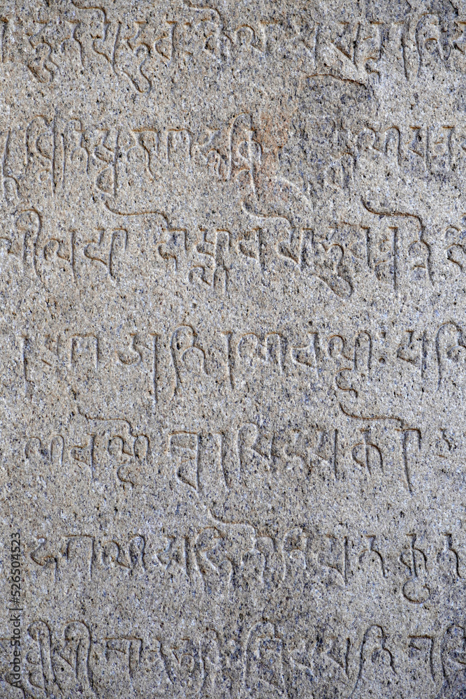 Inscriptions of tamil text on the walls of historical ancient temple in Tamilnadu. Ancient tamil inscriptions carved in the exterior temple walls. Stone wall texture.