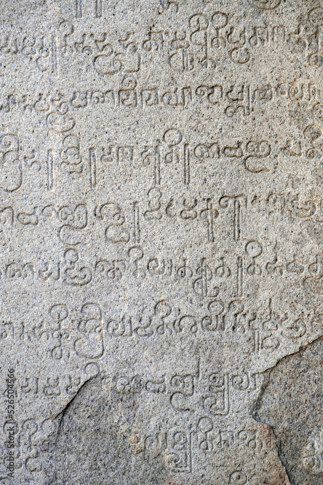 Inscriptions of tamil text on the walls of historical ancient temple in Tamilnadu. Ancient tamil inscriptions carved in the exterior temple walls. Stone wall texture.