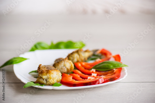Pieces of fried hake fish in a plate with pepper