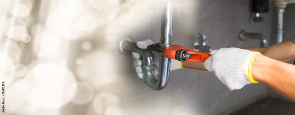 Plumber fixing white sink pipe with adjustable wrench. Plumber fixing white sink pipe with adjustable wrench.