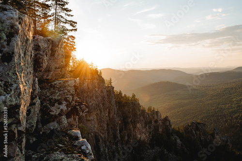A beautiful landscape in the mountains at sunset, the evening sun glare orange, the mountain range is rocky, the southern Urals mount Karatash.