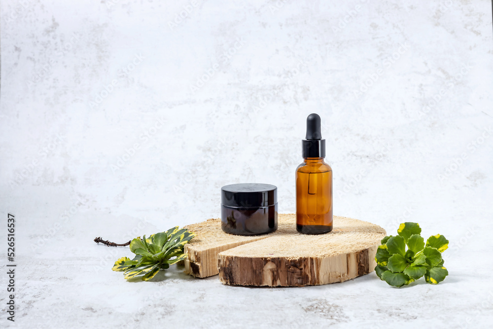 Naklejka premium containers for cosmetics on the podium made of cut wood and green flower leaves