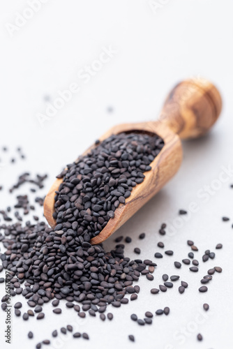 Bio natural sesame seeds on wooden spoon.