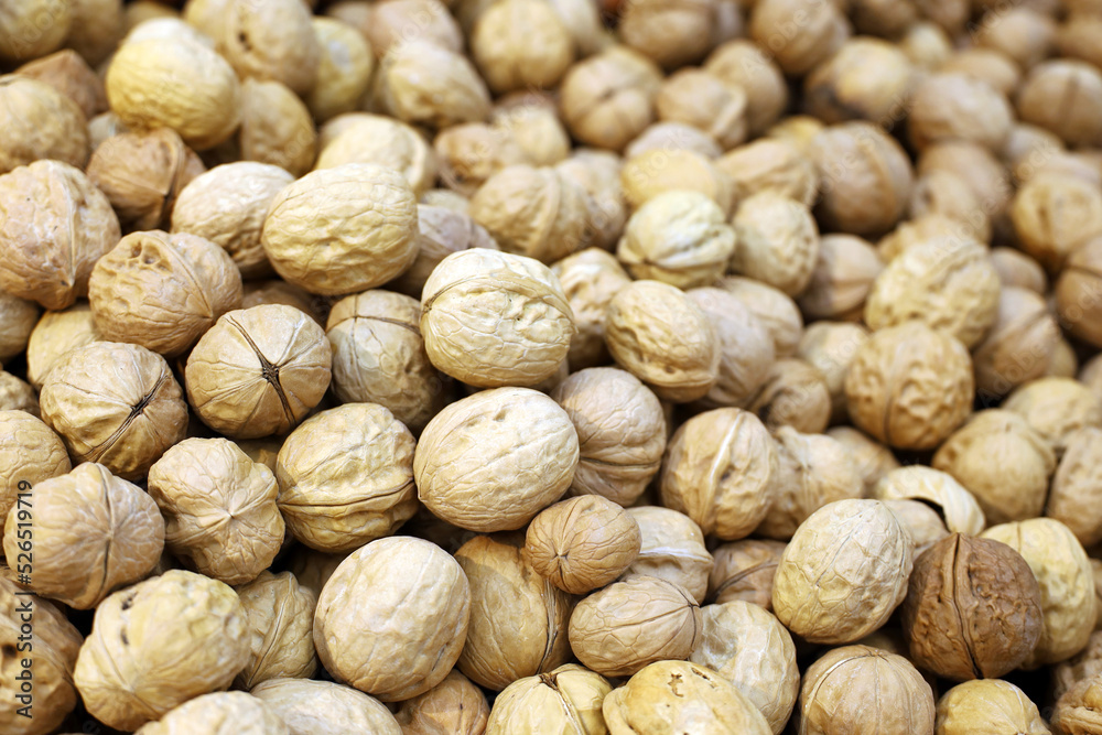Walnuts heap for background. Dry nuts in shells on a market, protein food for brain health Walnuts heap for background. Dry nuts in shells on a market, protein food for brain health