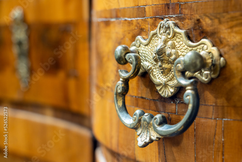 Obraz na plátně Decorative metal drawer handle in an antique desk with inlaid wood, Mid-18th century, close up