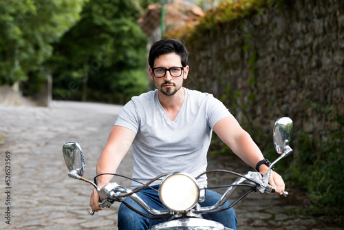 Bild auf Leinwand man driving a motorcycle without a helmet on the road in violation of road safety rules, dangerous driving on a motorcycle
