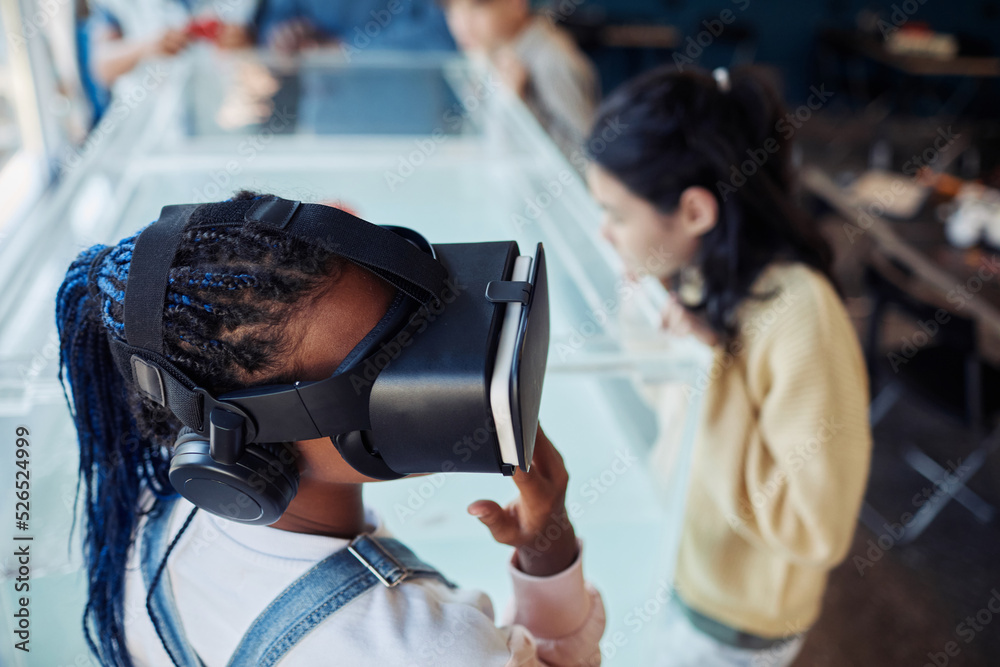 High angle portrait of black teenage girl wearing VR headset in scince class at modern school