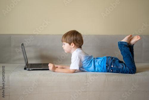 Distance learning online education. A schoolboy boy studies at home and does school homework. A home distance learning.