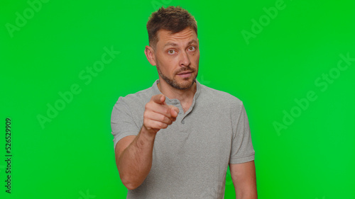 Hey you. Bearded handsome young man smiling excitedly and pointing to camera, choosing lucky winner, indicating to awesome you. Adult guy isolated alone on green chroma key studio background indoors