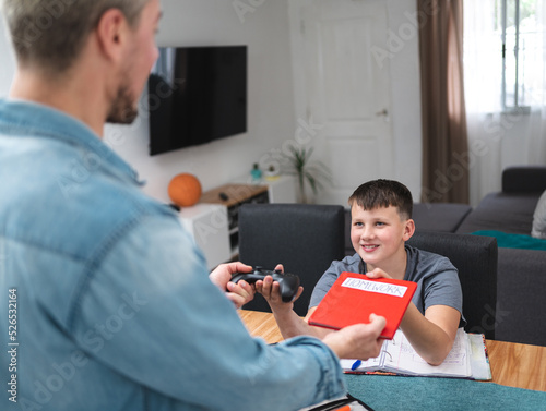 Caucasian boy swaps homework and receives joystick for playing video games in exchange
