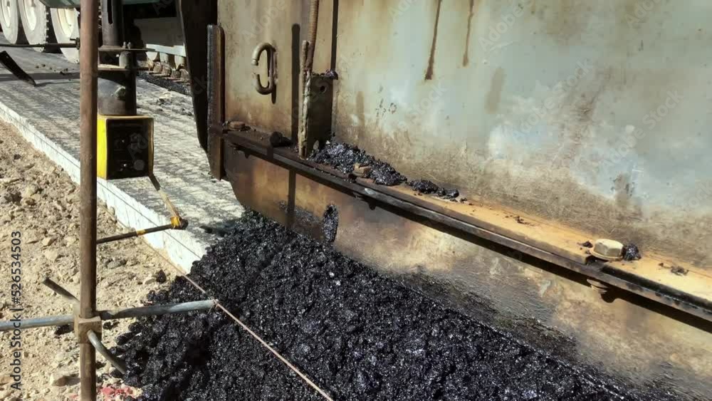 Paver Train Asphalt paver lays asphalt mix on concrete foundation. Black top paver ...