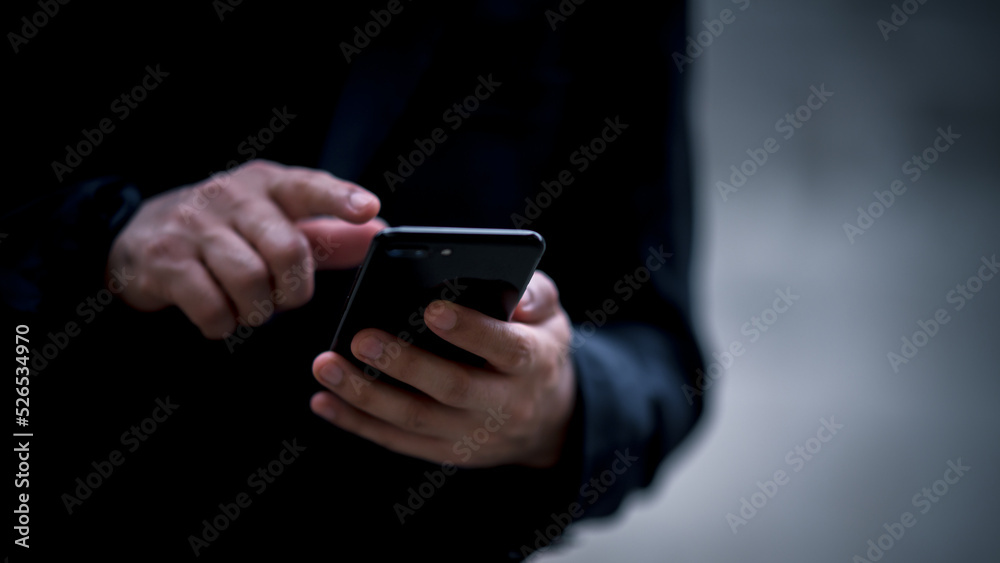 Close up on casual Man using smart phone, using mobile smart phone and online working on laptop computer at home office. Close up on casual Man using smart phone, using mobile smart phone and online working on laptop computer at home office.