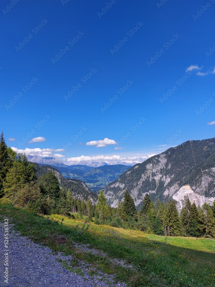 Bergpanorama mit grünen Tälern und blauen Himmel in den Alpen Bergpanorama mit grünen Tälern und blauen Himmel in den Alpen