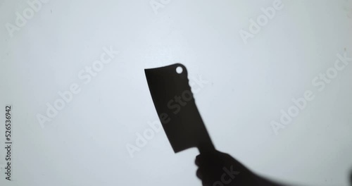 The shadow of a murderer kills his victim with a knife at night.
 photo
