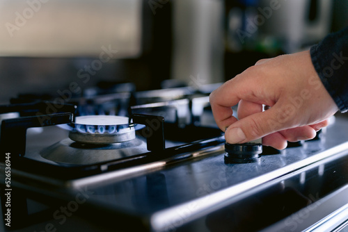 A stove is fired by natural gas, A hand turns on a stove fired by natural gas.

