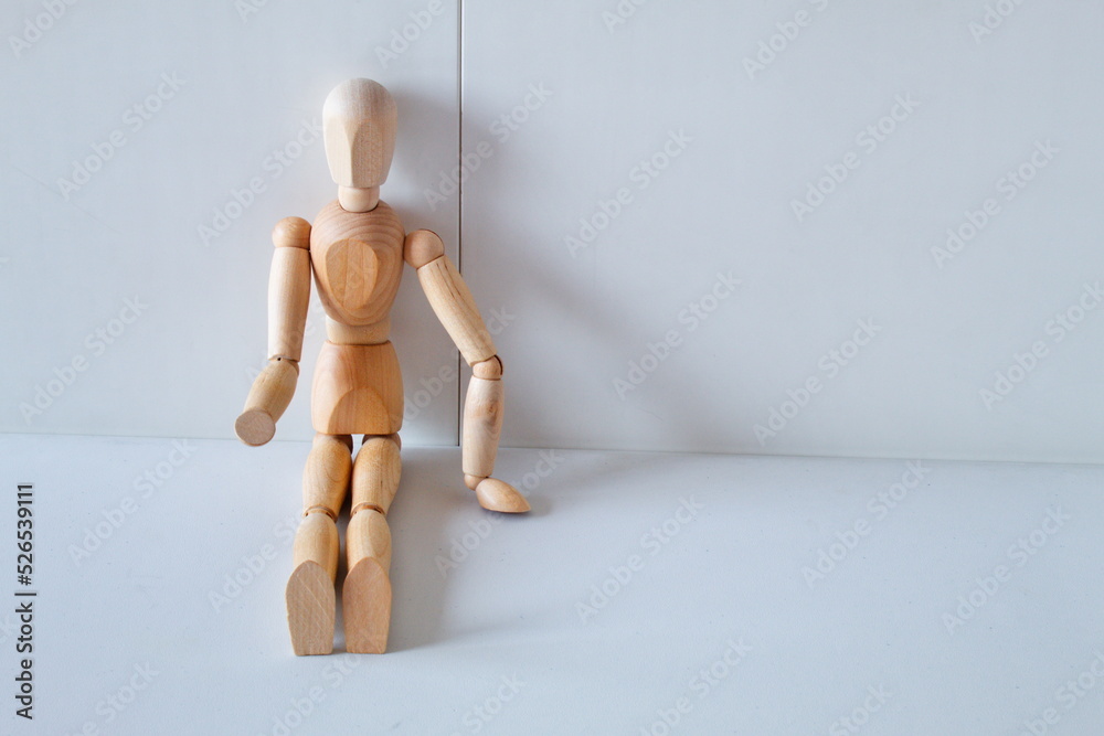Concept of loneliness, poverty and abandonment with a wooden doll asking as a model Concept of loneliness, poverty and abandonment with a wooden doll asking as a model